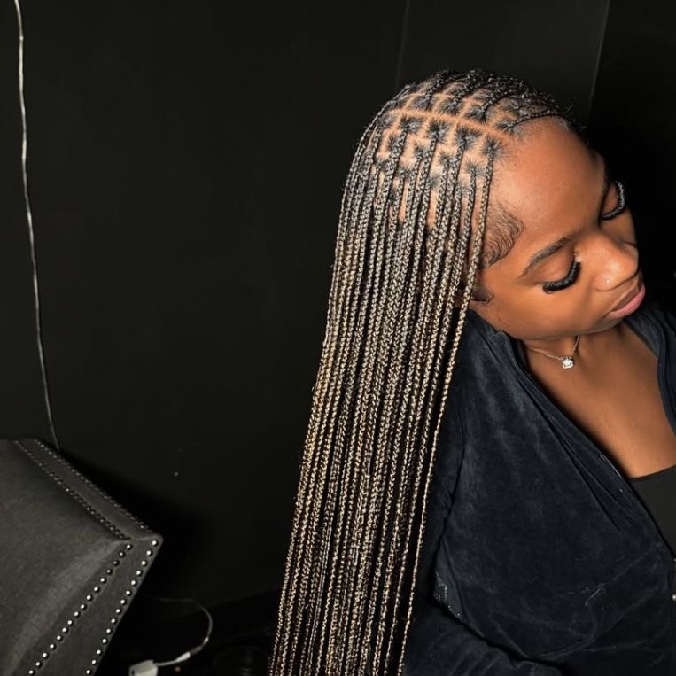 Gros plan sur le départ d'une tresse knotless posée au salon