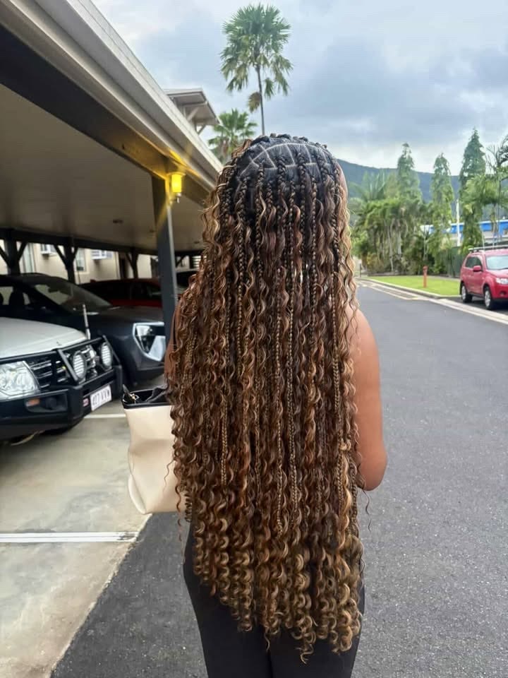 Une pose de bohobraids longues réalisée au salon, vue de dos, du crâne aux pointes